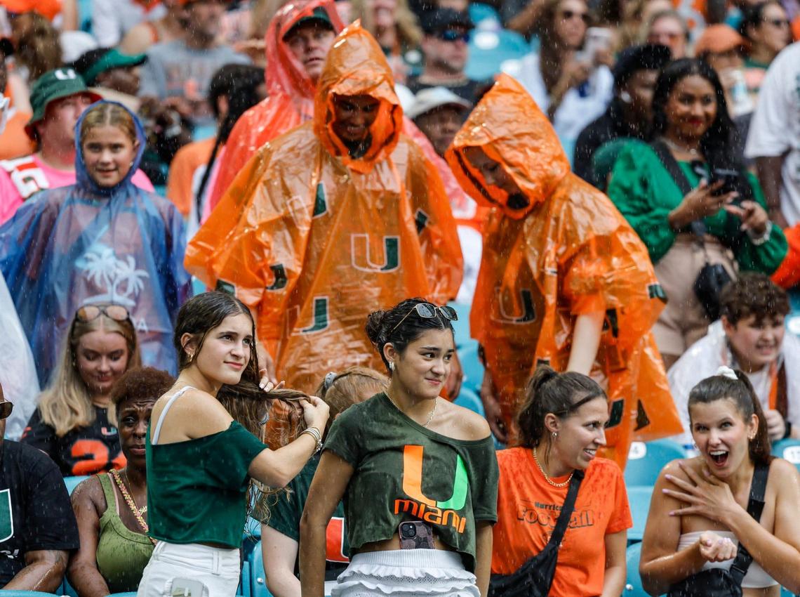 Football fans react as it starts to rain before The start of the Miami Hurricanes NCAA football game against the Ball State Cardinals at Hard Rock Stadium in Miami Gardens, Florida on Saturday, September 14, 2024.