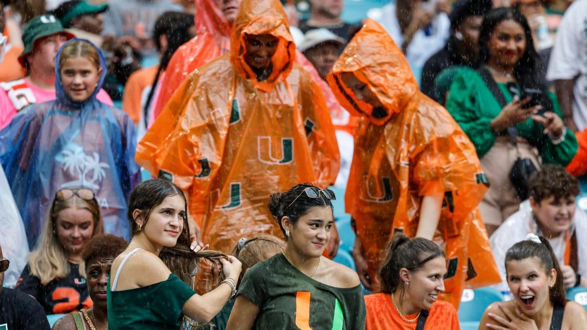 Football fans react as it starts to rain before The start of the Miami Hurricanes NCAA football game against the Ball State Cardinals at Hard Rock Stadium in Miami Gardens, Florida on Saturday, September 14, 2024.