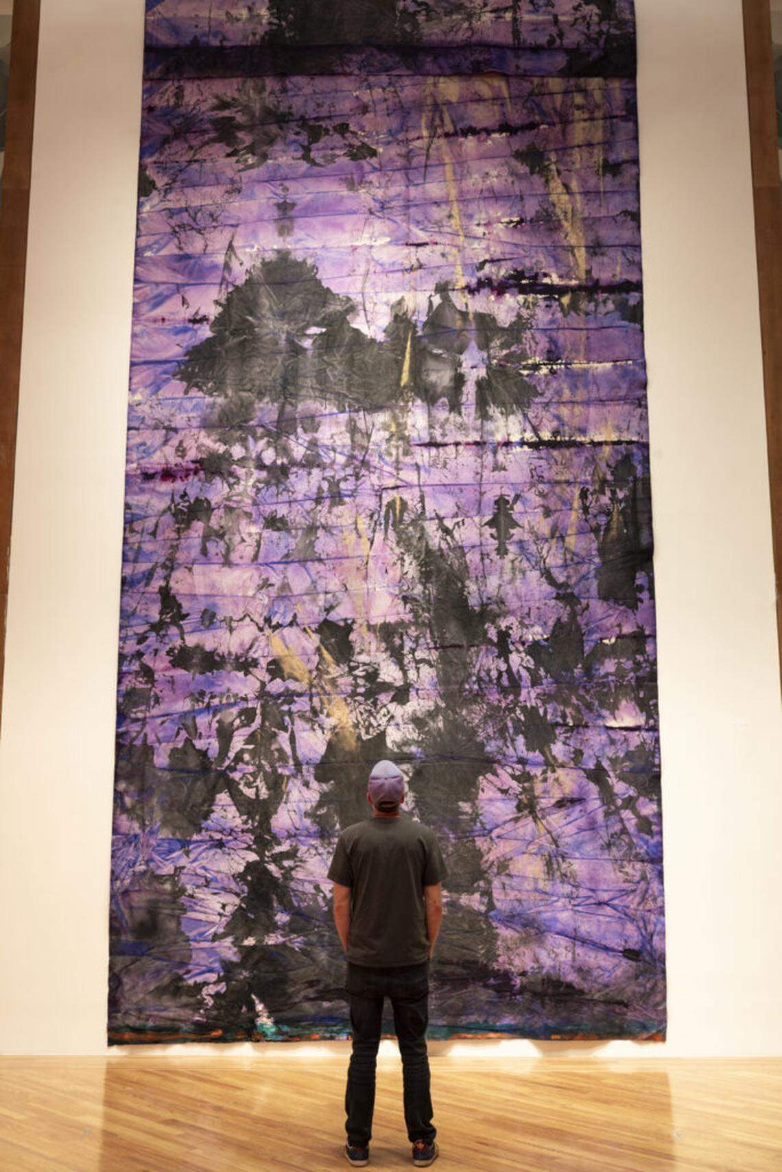A visitor stands in front of Mette Tommerup’s floor to ceiling canvas wall tapestry Rothko inspired “Which She Adores,” 2024.