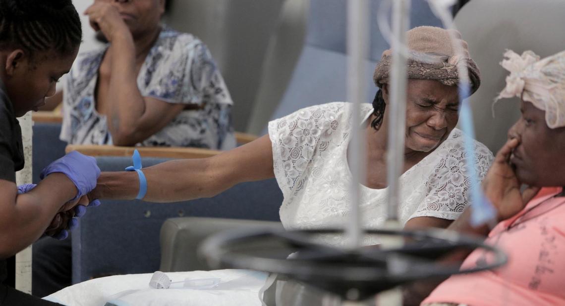 Feonia Licin, 51, grimaces as the nurse prepares her to receive chemotherapy. The mother of a 9 year-old son, Licin had a breast removed in December. Next to her is Paula Paul, 44, diagnosed in April with advanced cervical cancer.