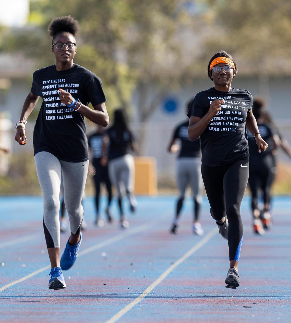 Shakynah Tresvant, 16, left, and Jean Mary, 18, both members of the Miami Northwestern Senior High track and field team, run warm-up drills at their school on Wednesday, Feb. 8, 2023, in Miami, Fla.