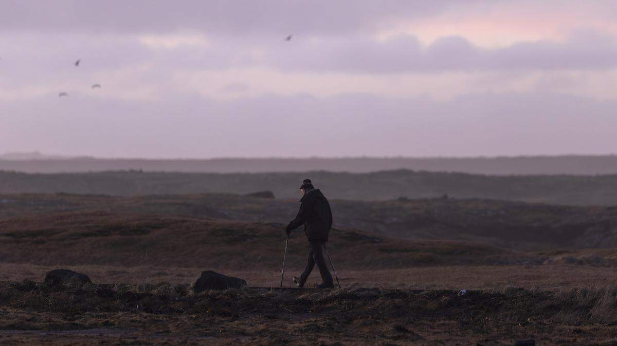 A person walks on the outskirts of Grindavik on December 20, 2025 in Grindavik, Iceland.