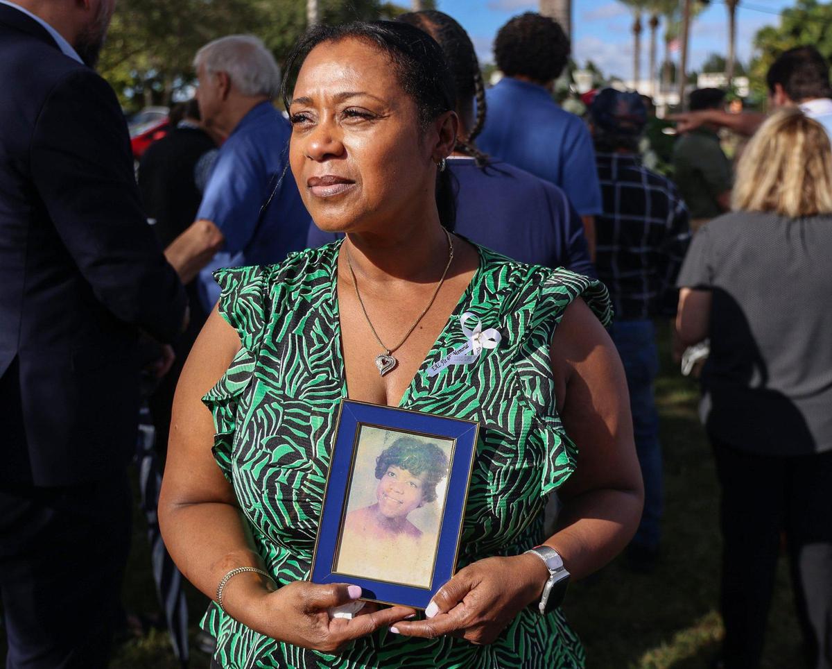 Nichole Shackelford sostiene una foto de su madre Patricia Renee Shackelford, quien murió en el vuelo 401 cuando ella tenía tres años, mientras asiste a la inauguración del monumento.