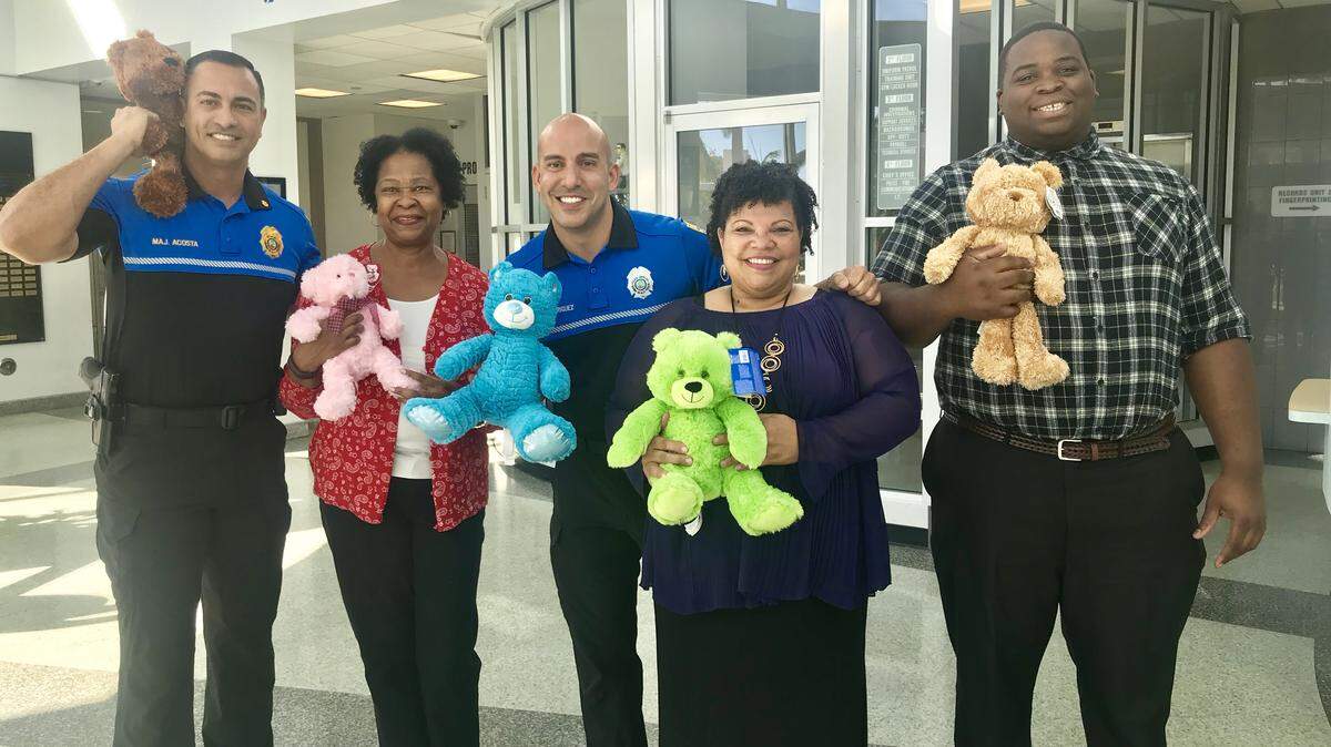 The Early Learning Coalition of Miami-Dade/Monroe recently collected teddy bears for the children of immigrant families who were separated from their parents and placed in a Miami-Dade shelter. At a similar drive, teddy bears were given to the Miami Beach Police Department to help children through police-related situations. From left are:  Miami Beach Police Major Paul Acosta, Jackye Russell of ELC, Miami Beach Police Officer Ernesto Rodriguez, Elaine Flores of Miami Beach Police, and Corey Jackson of ELC.