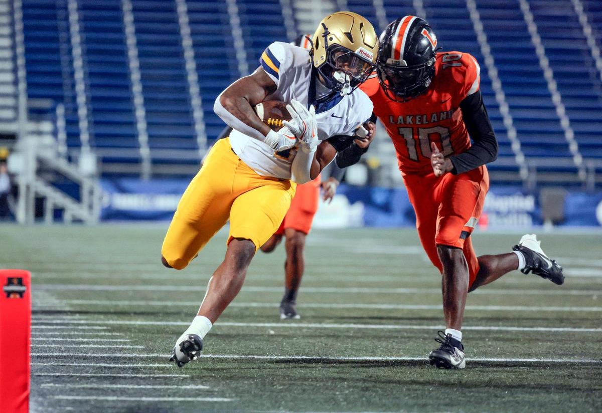 St. Thomas Aquinas running back Cedric Wyche II (4), runs in to score as Lakeland Dreadnoughts Jheden Williams (10) defends in the first half during the Florida High School Football State Championships - Class 5A game at Pitbull Stadium on the campus of Florida International University in Miami, Florida, on Thursday, December 12, 2024.