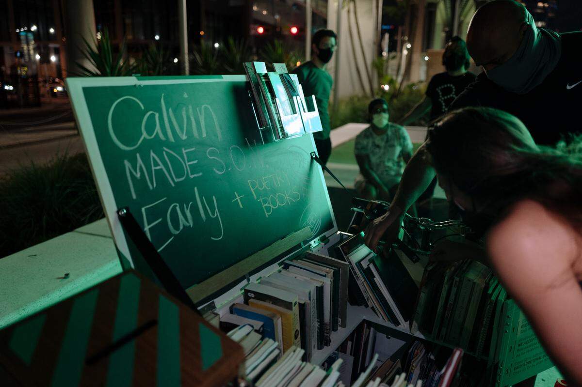 Readers check out Bookleggers Library mobile bike at an event at Miami’s Underline. The mobile library nonprofit received a grant from the Jorge Pérez Family Foundation.