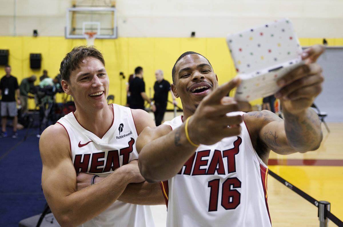 Pelle Larsson (9) and Keshad Johnson (16) take a photo on a gaming device while they wait to be interviewed during the Miami HEAT Media Day on Monday, Sept. 29, 2025, at the Kaseya Center in downtown Miami, Fla.