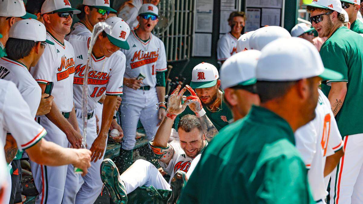 Miami Hurricanes infielder CJ Kayfus (2) celebrates in the dugout with teammates after a homer in the fourth inning against the Duke at Mark Light Field at Alex Rodriguez Park in Coral Gables, Florida on Saturday, May 20, 2023.
