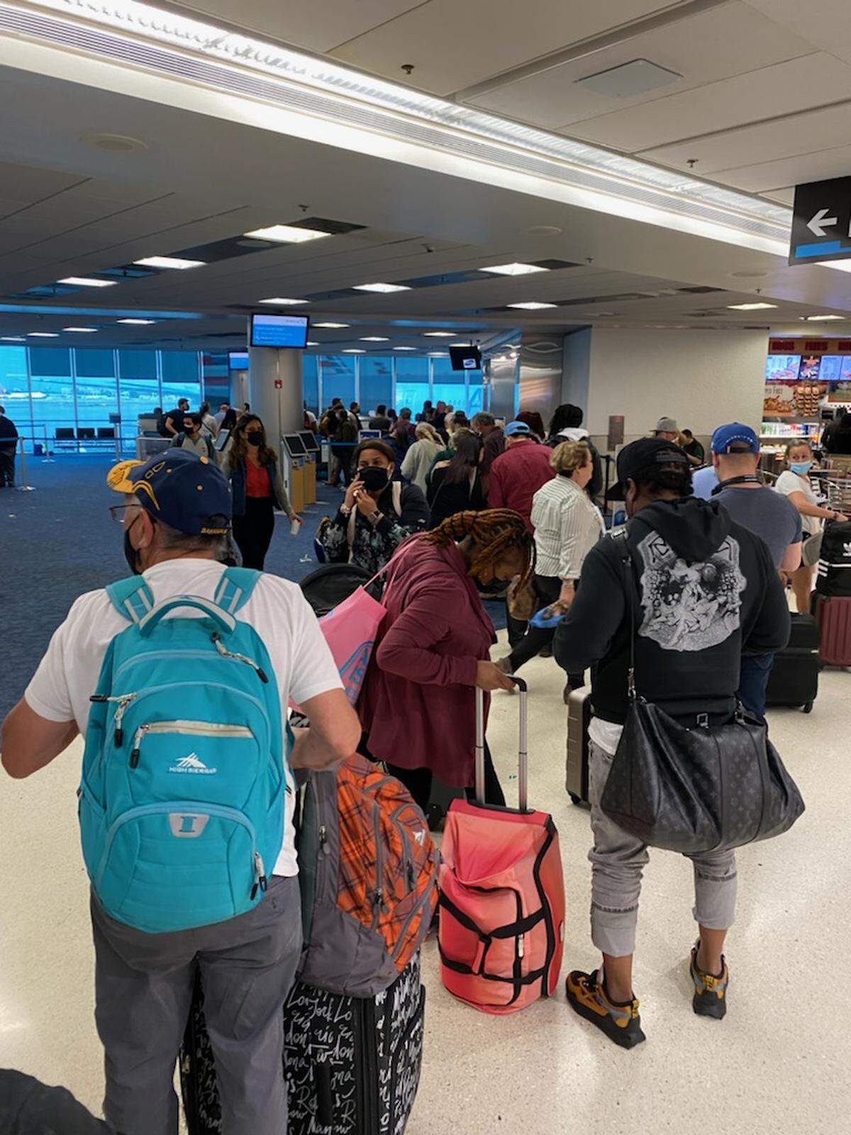 People stand in a rebooking line at the American Airlines terminal in Miami International Airport Friday, April 1, 2022. Airport officials say stormy weather Thursday and Friday caused flight cancellations and backups.