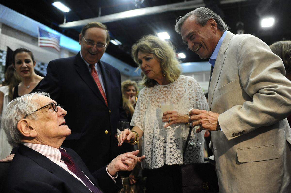 Longtime Ransom Everglades high school English teacher Dan Bowden speaks to former classmate Dr. Julio Pita (right) along with his wife Patricia and Dr. Gene Safye  on June 4, 2016, at the Ransom Everglades Upper School gymnasium. Bowden was being honored for his 60 years of teaching as well as his 84th birthday celebration by former students, relatives and friends.