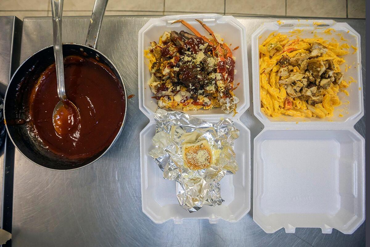 A selection of Chef Syerra Donaldson’s signature dishes — loaded seafood mac and cheese, creamy pasta with grilled chicken, and a garlic butter roll — served at EasyCookinWithSy in Miami Gardens on Saturday, May 24, 2025.
