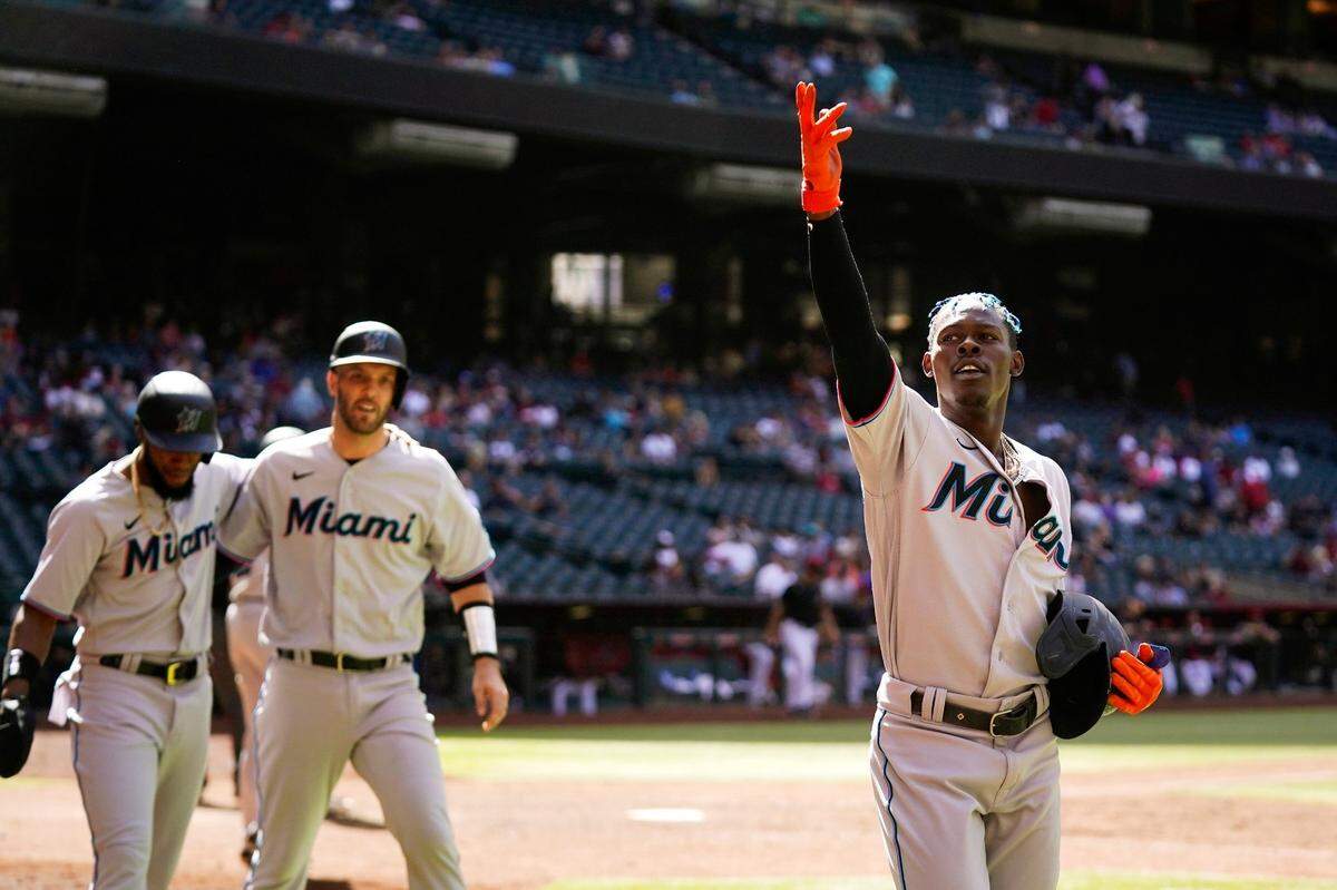Miami Marlins’ Jazz Chisholm Jr., right, celebrates his three-run home run against the Arizona Diamondbacks with Marlins’ Jacob Stallings, middle, and Bryan De La Cruz, left, during the ninth inning of a baseball game Wednesday, May 11, 2022, in Phoenix.