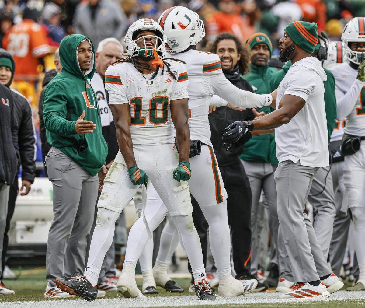 Miami Hurricanes wide receiver Malachi Toney (10) and quarterback Carson Beck (11) celebrate on the sidelines after Toney scores on a pass reception during the first half against the Pittsburgh Panthers during their NCAA football game at Acrisure Stadium in Pittsburgh, PA, on Saturday, November 29, 2025.
