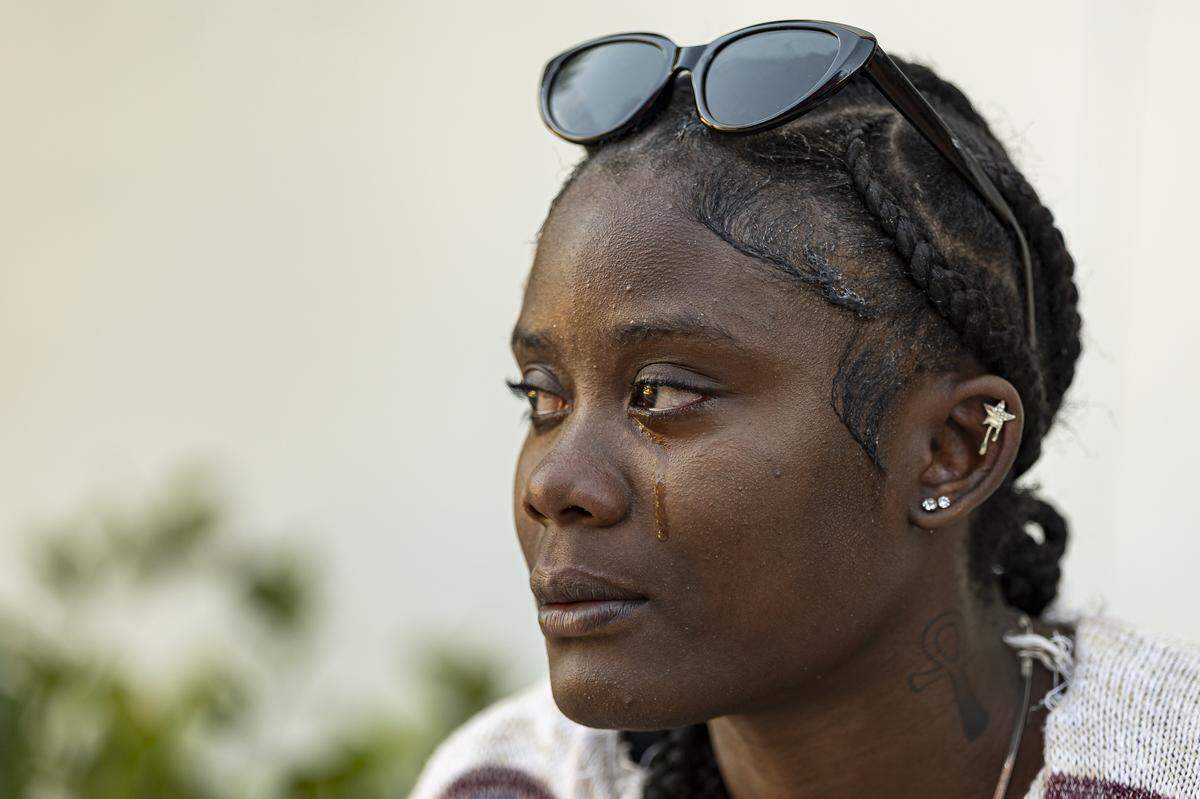 Nathalia Hall, 18, sheds a tear as she talks about her living situation outside of the Lotus House Women's Shelter on Tuesday, Nov. 18, 2025, in Miami, Fla.