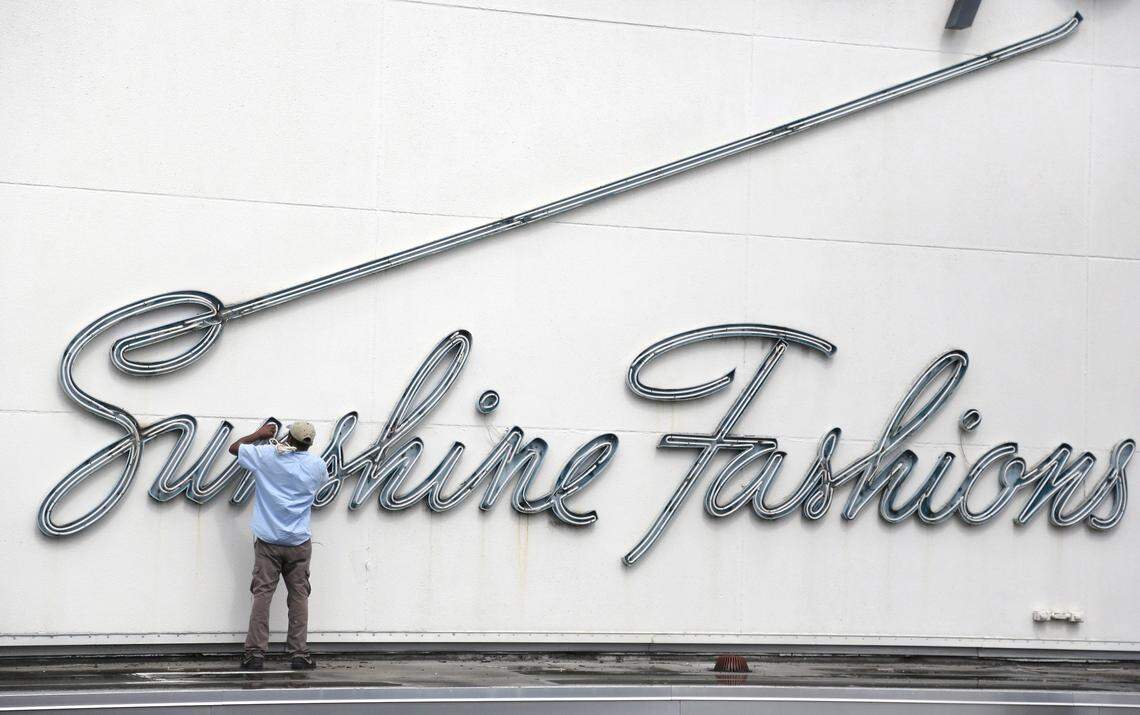 Ian Burton, 48, owner of Ian Signs and Services repair the “Sunshine” neon sign on the exterior of the historic and former Burdines store (now Macy’s).