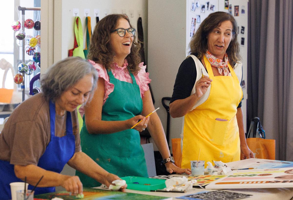 Macarena Maiman, center, laughs while Maja Guzina, right, and Mirna De Los Santos, left, work on their art during open studio time in an art class for people over 55 years of age at Perez Art Museum Miami in downtown Miami.