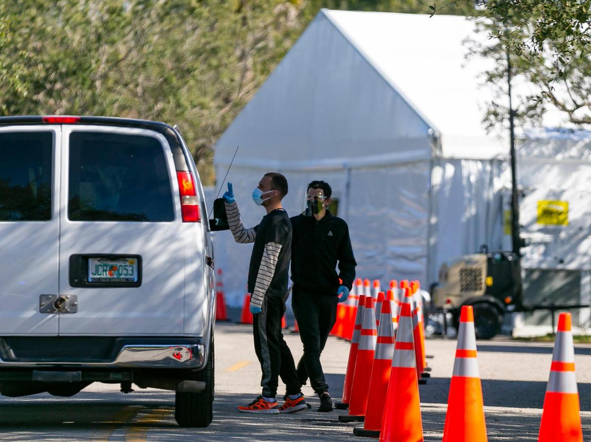 Workers can be seen outside of a monoclonal antibody treatment site for COVID-19 at Markham Park in Sunrise, Florida on Wednesday, January 19, 2022.
