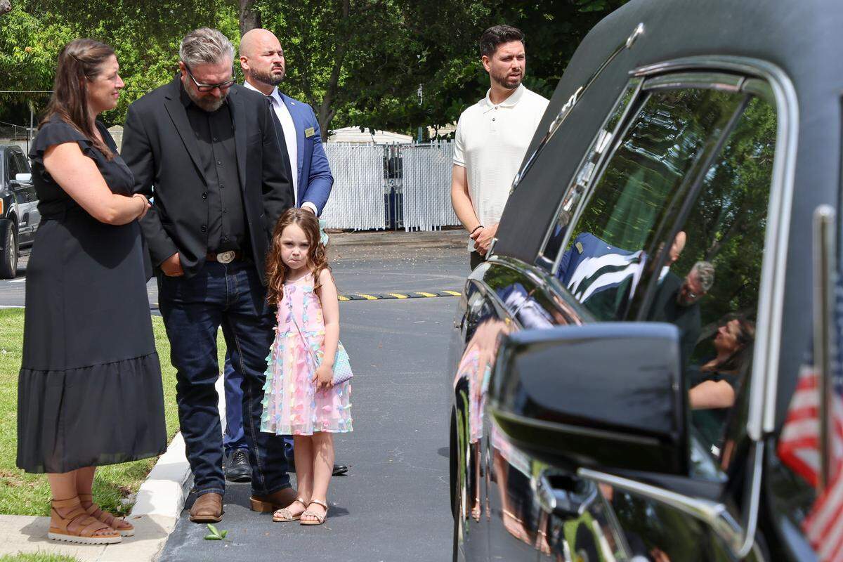 The grand and great-grandchildren stand near the hearse as it prepares to leave the church.  Former Miami-Dade School Board member Holmes Braddock, who passed away at 100, was honored at his celebration of life service on July 27, 2025, at Kendall United Methodist Church in Miami, Florida.