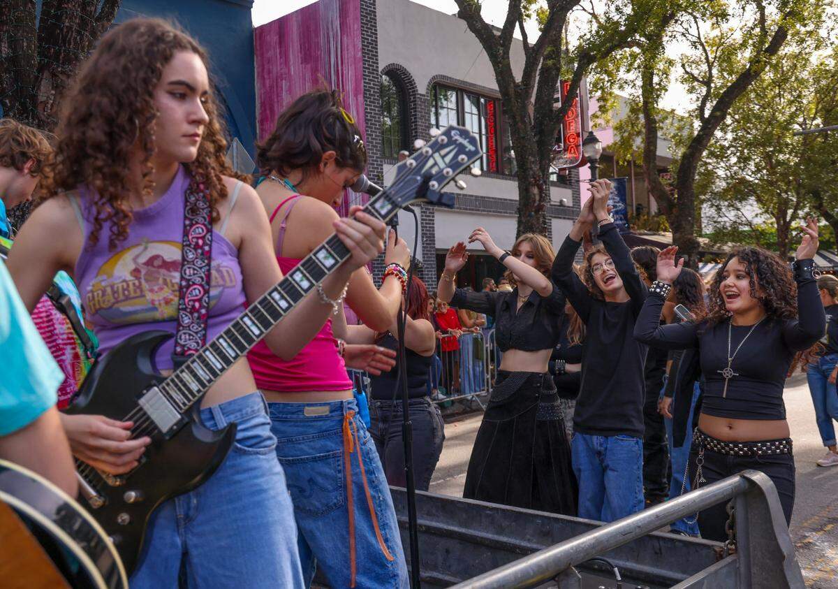 School of Rock students dance as fellow students play while the vibrant and quirky 41st Annual King Mango Strut Parade made its way through the Grove.