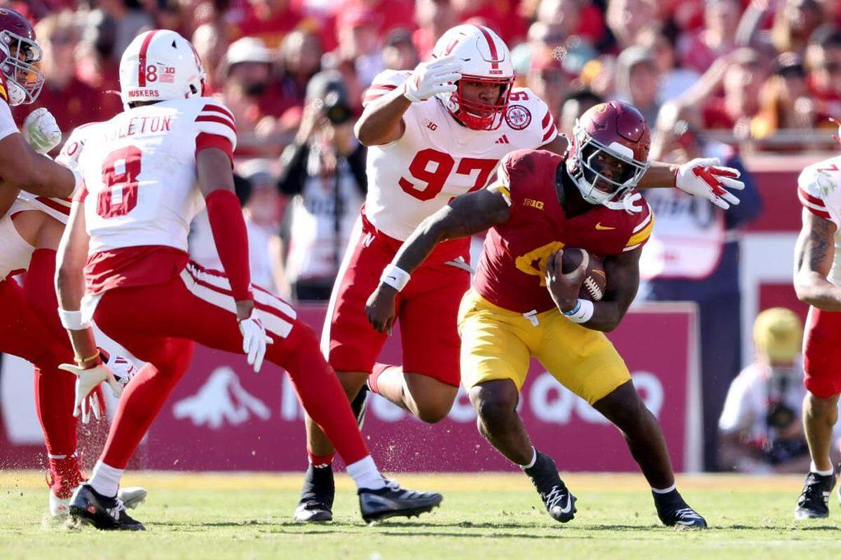 LOS ANGELES, CALIFORNIA - NOVEMBER 16: Woody Marks #4 of the USC Trojans rushes as he avoids the defense of Keona Davis #97 and DeShon Singleton #8 of the Nebraska Cornhuskers during the first half of a game at United Airlines Field at the Los Angeles Memorial Coliseum on November 16, 2024 in Los Angeles, California. (Photo by Sean M. Haffey/Getty Images)