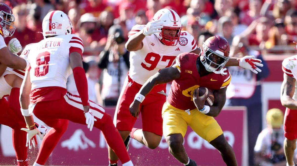 LOS ANGELES, CALIFORNIA - NOVEMBER 16: Woody Marks #4 of the USC Trojans rushes as he avoids the defense of Keona Davis #97 and DeShon Singleton #8 of the Nebraska Cornhuskers during the first half of a game at United Airlines Field at the Los Angeles Memorial Coliseum on November 16, 2024 in Los Angeles, California.  (Photo by Sean M. Haffey/Getty Images)