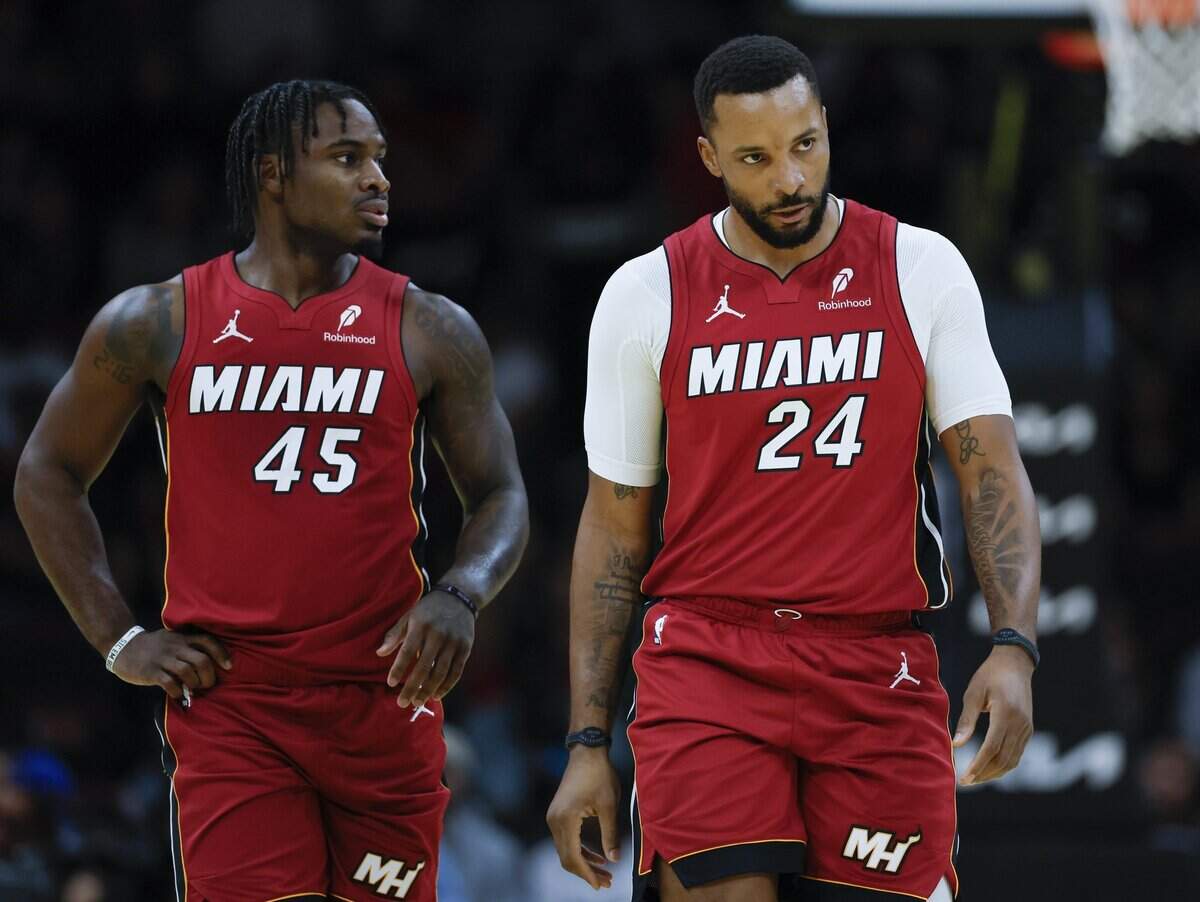 Miami Heat guard Davion Mitchell (45) and guard Norman Powell (24) walk together on the court in the first half against the Milwaukee Bucks during their NBA basketball game at Kaseya Center in Miami on November 26, 2025.