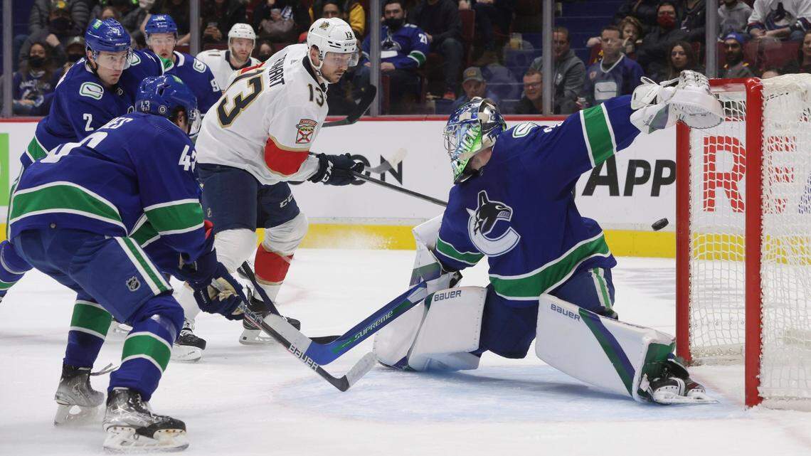Florida Panthers’ Sam Reinhart (13) has his shot deflect off the post behind Vancouver Canucks goalie Spencer Martin, right, and stay out of the goal during the first period of an NHL hockey game Friday, Jan. 21, 2022, in Vancouver, British Columbia. (Darryl Dyck/The Canadian Press via AP)