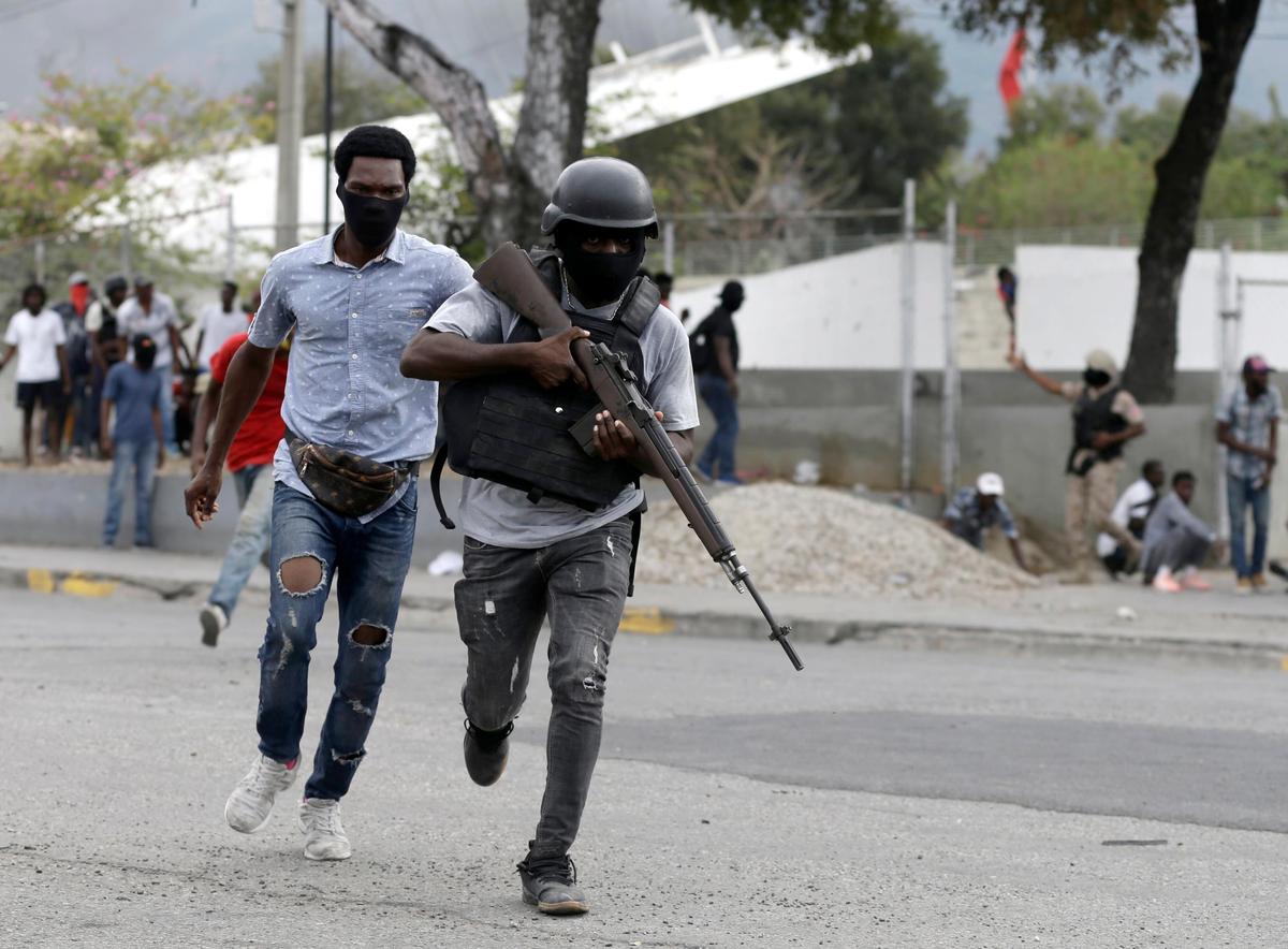 Off-duty police officers run towards an armed clash with army soldiers during a protest over police pay and working conditions, in Port-au-Prince, Haiti, Sunday, Feb. 23, 2020.
