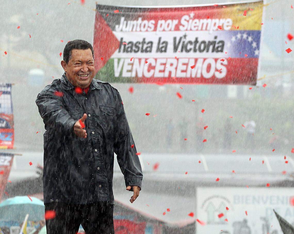 Venezuelan President Hugo Chavez, greets supporters under a heavy rain during his closing campaign rally on Avenida Bolivar, in Caracas, four days away from the presidential elections.