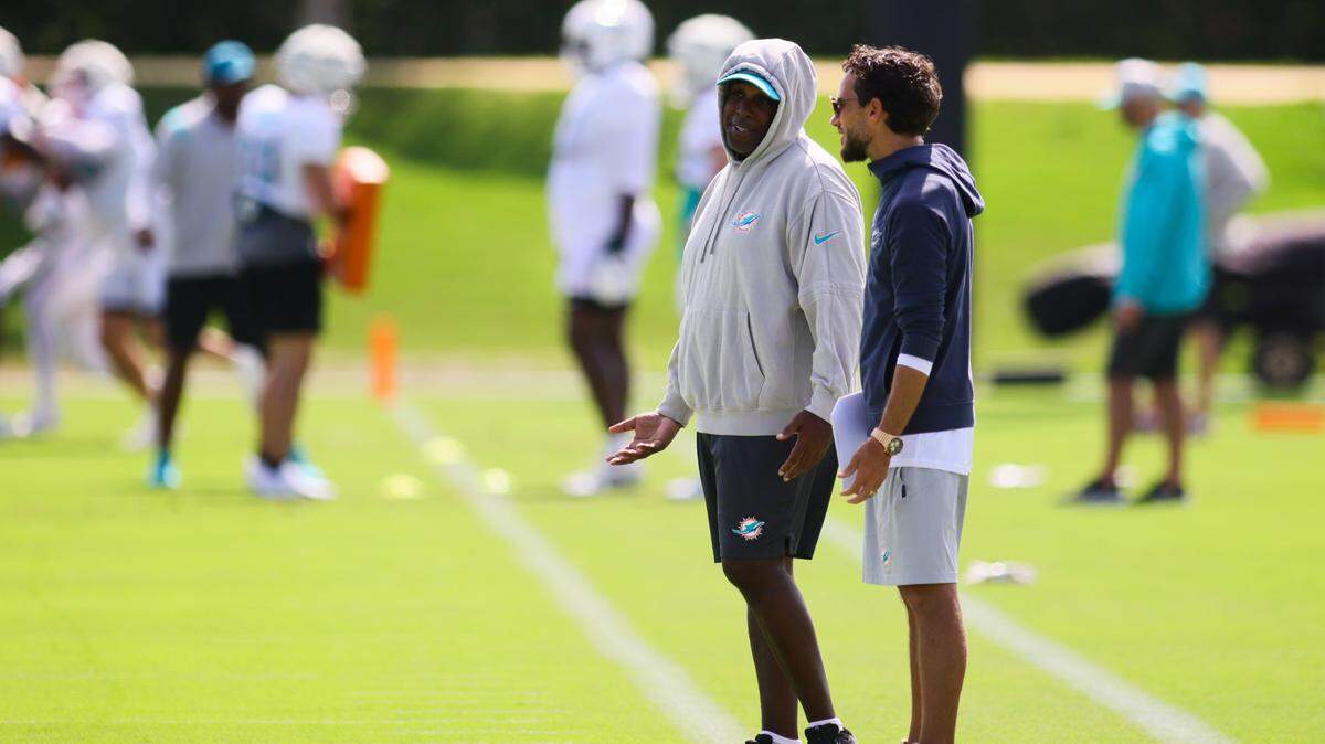 El gerente general de los Dolphins, Chris Grier (izq.), habla con el entrenador Mike McDaniel durante el campamento de entrenamiento en el Baptist Health Training Complex en Miami Gardens, Florida, el 20 de agosto de 2024.