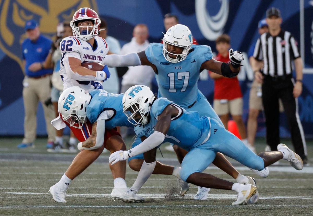 Louisiana Tech Bulldogs tight end Hunter Tipton (82) is stopped by Florida International University Panthers defensive lineman Claude Larkins (17), defensive back CJ Christian (4) and defensive back Jamal Potts (7) in the first half of an NCAA conference football game at Pitbull Stadium on Saturday, September 28, 2024, in Miami, Fla.