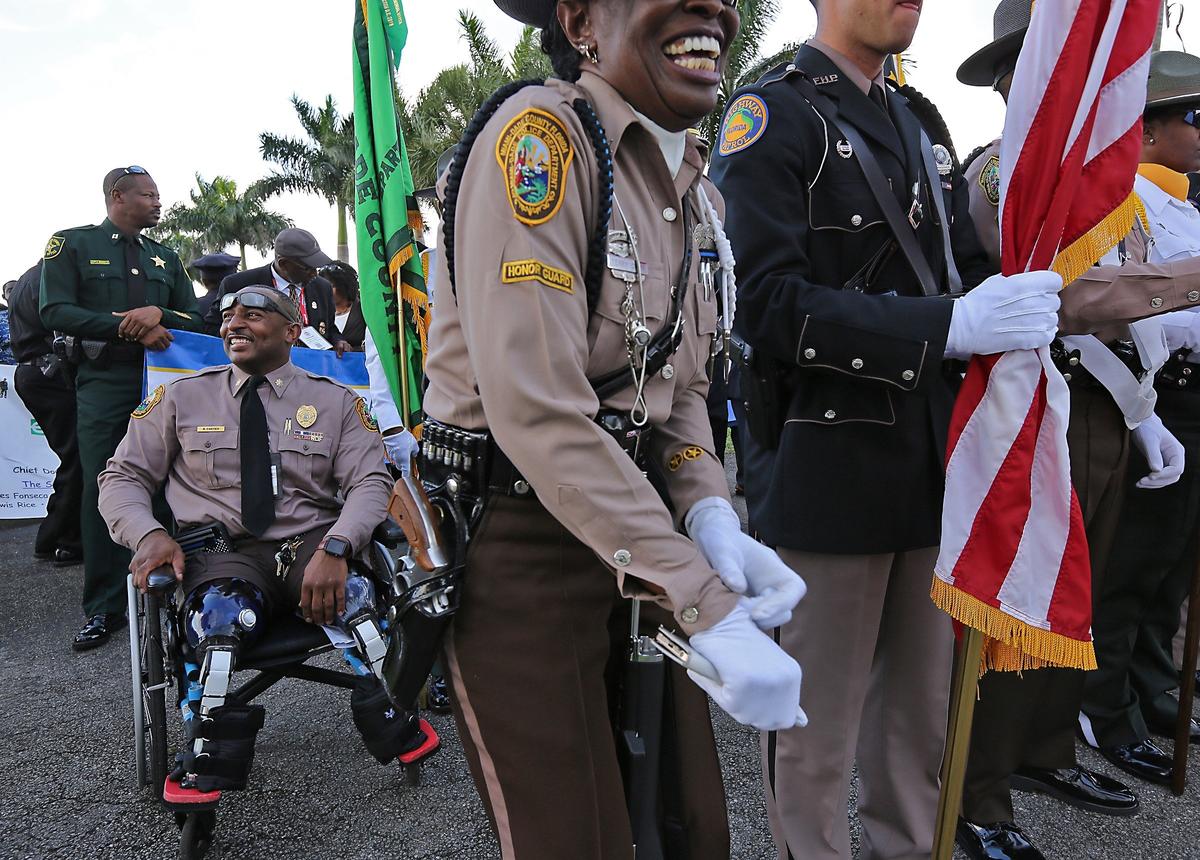 Miami-Dade Police Major Ricky Carter, left, joins in the march with fellow law enforcement officers and members of NOBLE (National Organization of Black Law Enforcement) from around the country who participated in a march from Calder Racetrack and Casino to Antioch Missionary Baptist Church in Miami Gardens for discussion regarding the shooting deaths and reducing gun violence in the city, Wednesday, Aug. 1, 2018.