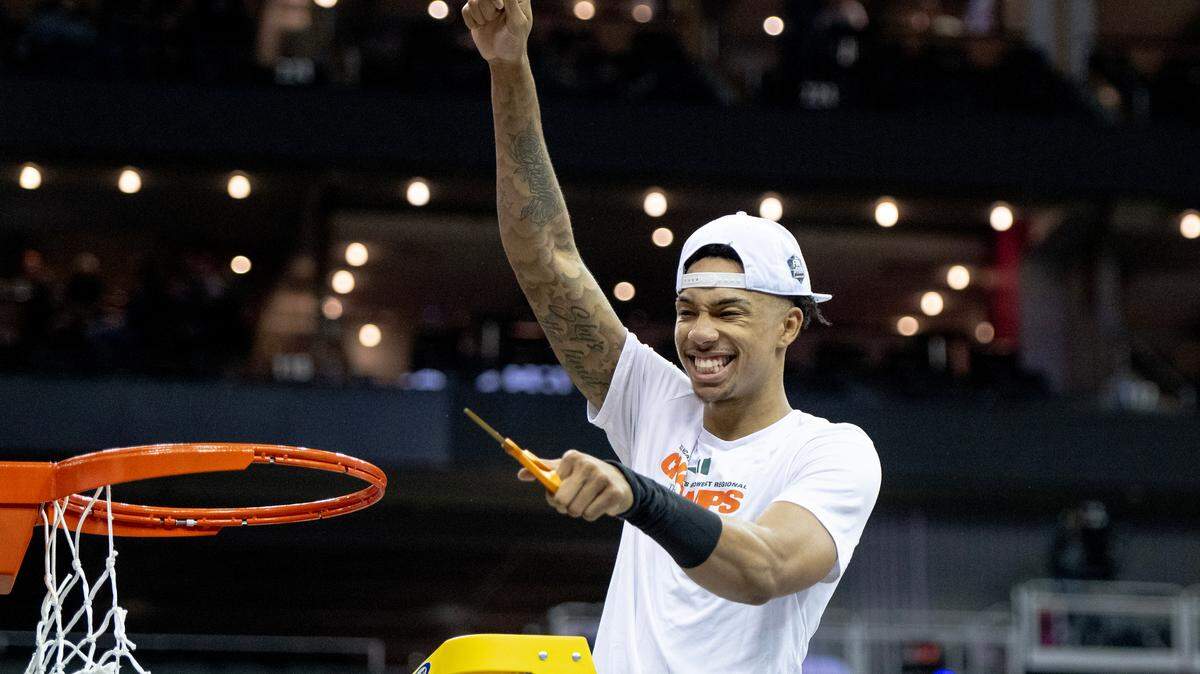 Miami guard Jordan Miller holds up a piece of a basket’s net as he celebrates defeating Texas 88-81 in an Elite 8 college basketball game in the Midwest Regional of the NCAA Tournament, Sunday, March 26, 2023, in Kansas City.