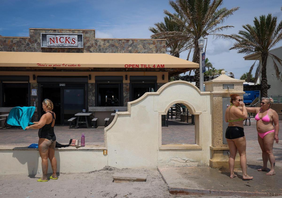 On Tuesday, May 30, 2023 police officers, tourists and locals mingle on the Hollywood Beach Broadwalk the day after a mass shooting left nine people injured. A witness recounts his efforts to help wounded people. --