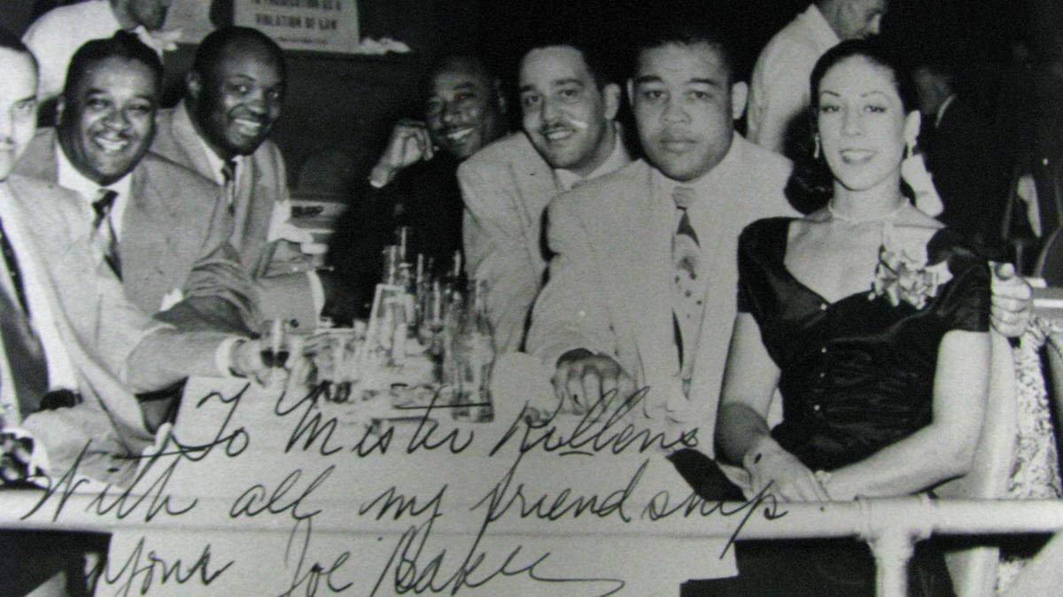 Singer/actress Josephine Baker and boxer Joe Louis with friends at the Knight Beat Club inside the Sir John Hotel. The photograph has a note to Clyde Killens, promoter, from Josephine Baker.