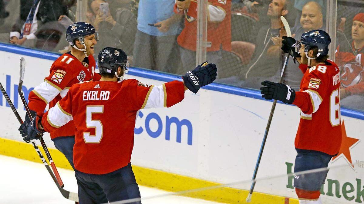Florida Panthers Mike Hoffman (68) celebrates his winning goal in overtime with Jonathan Huberdeau (11) and Aaron Ekblad (5) as they defeat the New Jersey Devils in overtime at the BB&T Center in Sunrise, Florida, Monday, November, 26, 2018.