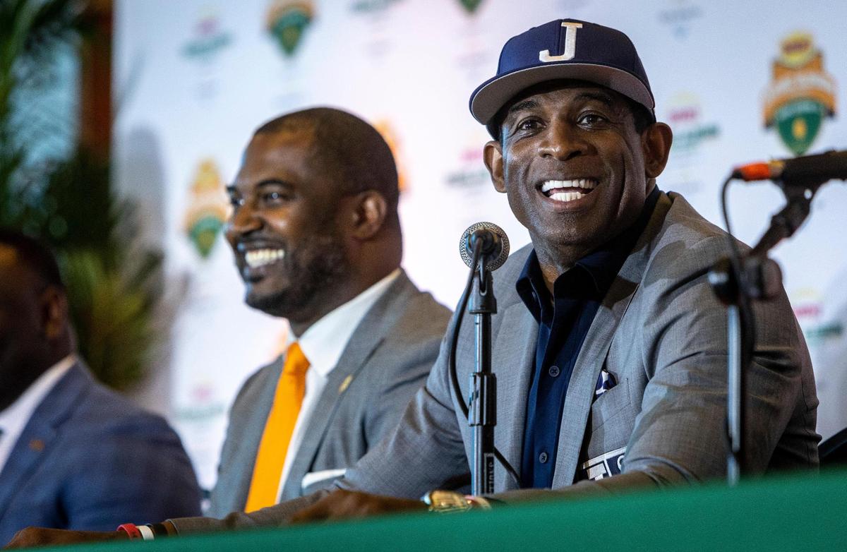 Deion Sanders, football coach at Jackson State University, right, speaks while Florida A&M coach Willie Simmons smiles during a May 5, 2021, press conference at Hard Rock Stadium to preview the Orange Blossom Classic.