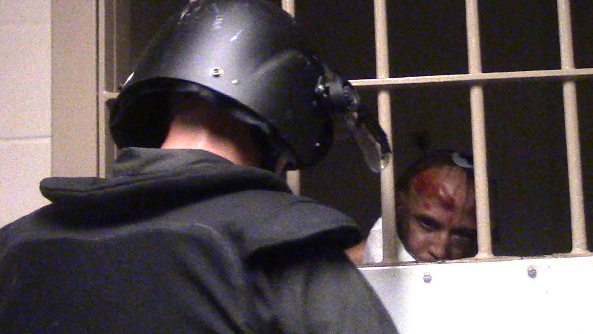 Michel Hernandez’s battered face is visible beneath the spit shield officers pulled over his head.