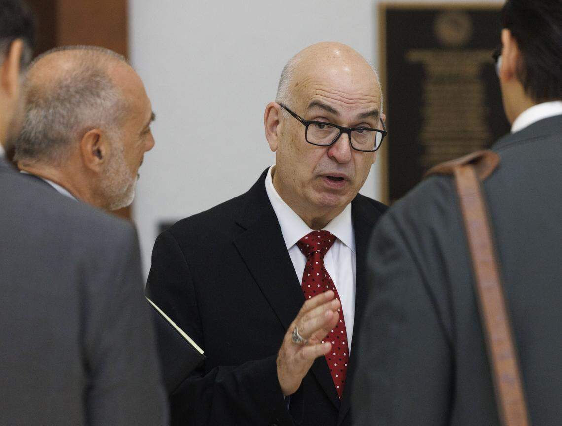 Emilio González, center, speaks to his legal team before a hearing at the Third District Court of Appeal for a case he brought against the City of Miami on Tuesday, July 29, 2025, in Miami. A lower court judge ruled in favor of González, declaring the city's ordinance to be unlawful. The judge said changing the election date requires amending the City Charter, which requires voter approval. The city appealed the decision.