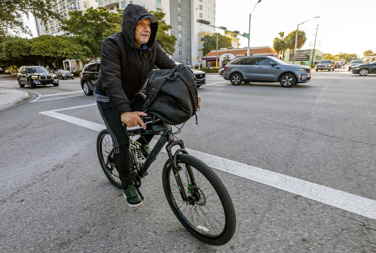 Alberto Contreras rides his bike wearing cold weather gear as he crosses Southwest 32 Ave. and Coral Way as the coldest air of the season arrives in South Florida on Wednesday morning, Jan. 8, 2025.