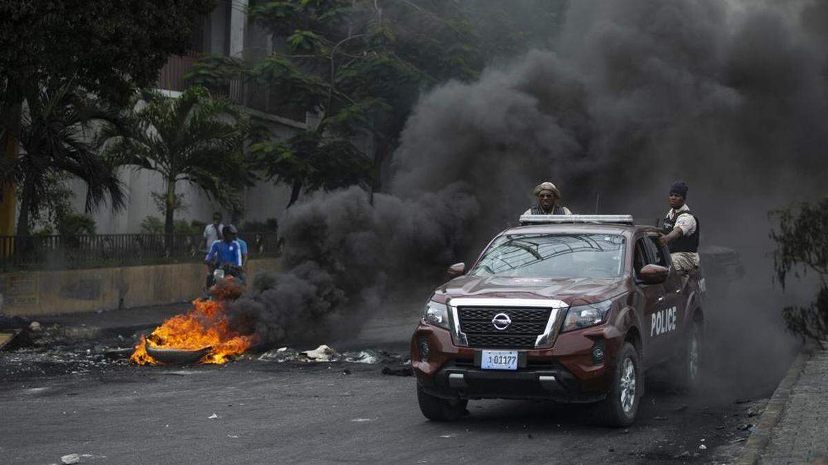 Police drive over a barricade set up by taxi drivers to protest fuel shortages in Port-au-Prince, in July.