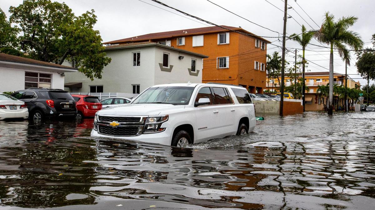 A car pushes through floodwaters off Southwest Third Street and Eighth Avenue in the Little Havana neighborhood of Miami, Florida, on Saturday, June 4, 2022.