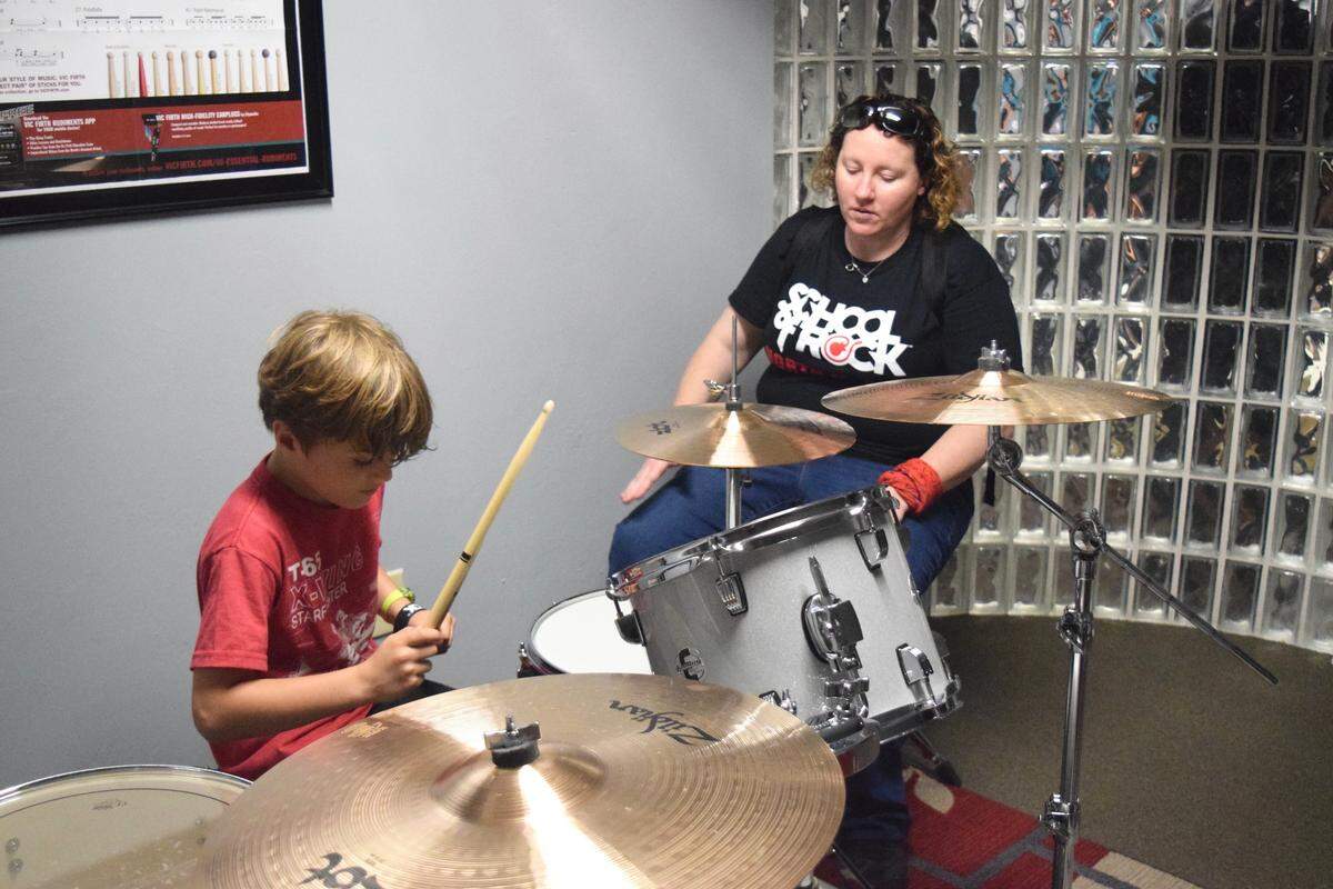 Drum teacher Trisha Stout mentors a student Saturday at School of Rock in North Miami.