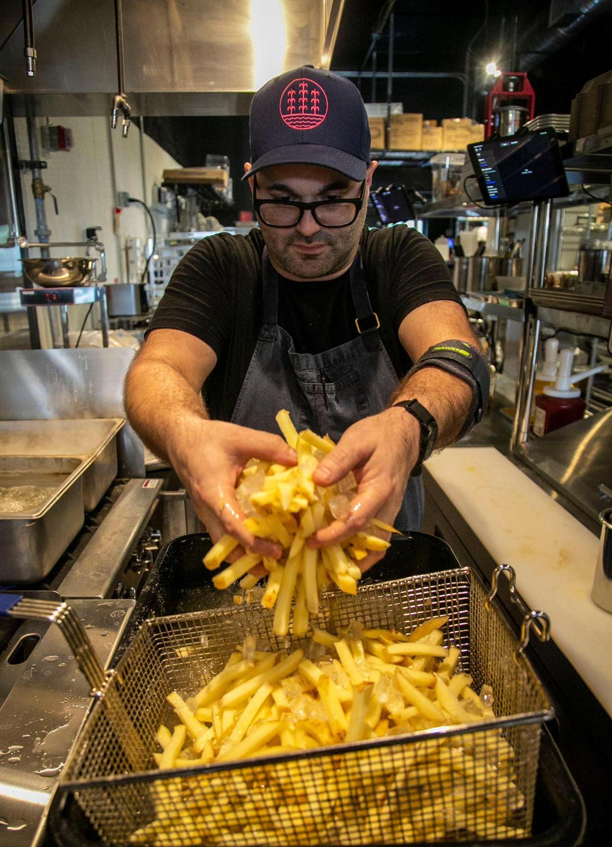 Miami, Florida, November 18, 2021 - Steve Santana blanches potatoes that will be served as French fries later when the restaurant opens.
