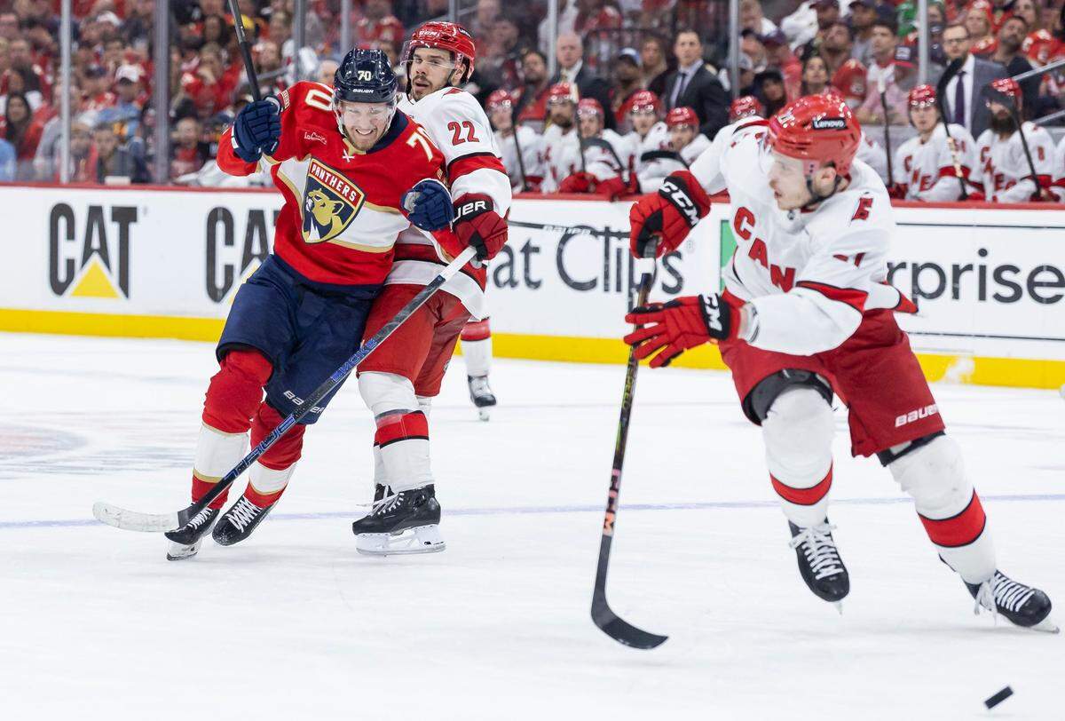 Carolina Hurricanes center Logan Stankoven (22) defends against Florida Panthers center Jesper Boqvist (70) as he chases after the puck in the second period of Game 4 during the Eastern Conference final of the NHL Stanley Cup playoffs at Amerant Bank Arena on Monday, May 26, 2025, in Sunrise, Fla.