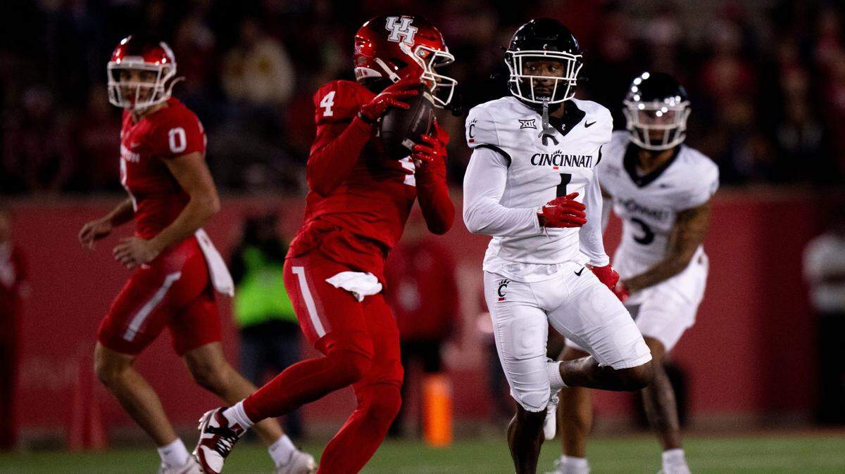 Houston Cougars wide receiver Samuel Brown (4) catches a pass as Cincinnati Bearcats cornerback Jordan Young (1) covers him in the second quarter of the NCAA football game between the Cincinnati Bearcats and the Houston Cougars TDECU Stadium in Houston, Texas, on Saturday, Nov. 11, 2023.