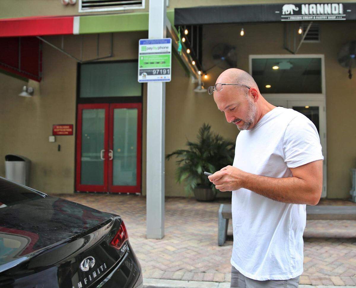 José Devayle usa la aplicación de estacionamiento PaybyPhone en esta foto de archivo de Miami del 21 de octubre de 2017.