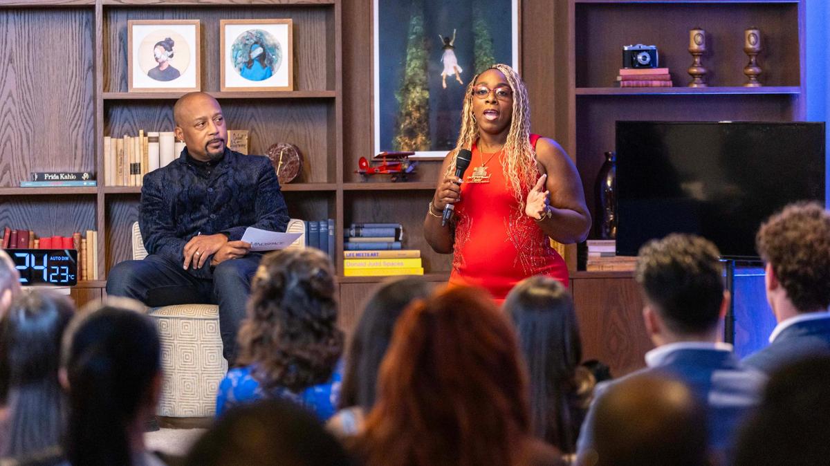 Daymond John, left, listens as owner of BF Employment Center, Barbara Parker, right, speaks to the audience during “The Big Pitch Night” event at Mindspace Miami on Tuesday, Nov. 19, 2024, in Miami, Fla.