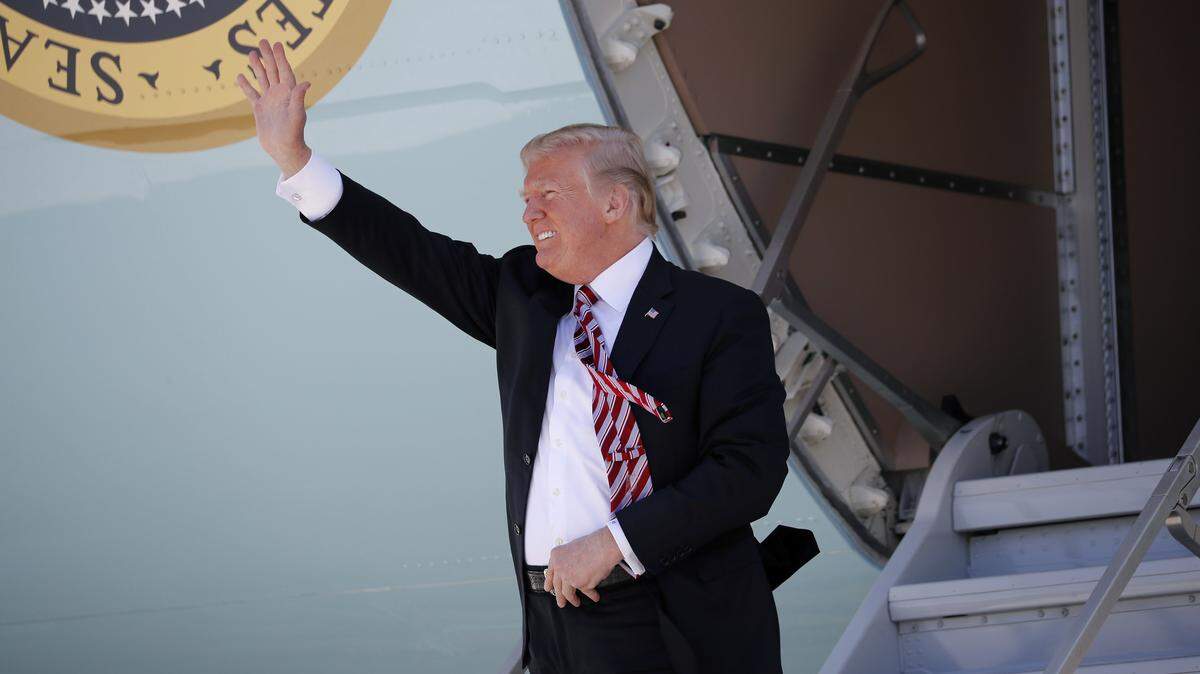 President Donald Trump waves during his arrival on Air Force One at Miami International Airport, Monday, April 16, 2018, in Miami. Trump traveled to Florida to promote his $1.5 trillion tax cut package he signed into law. Miami-Dade Mayor Carlos Gimenez said he wanted to be there to greet him, but the White House declined.