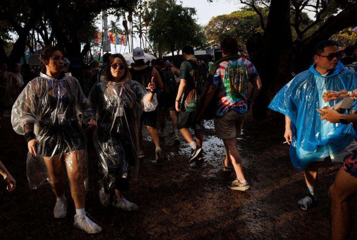 Attendees walk through the puddles during the third day of Ultra Music Festival on Sunday, March 30, 2025, at Bayfront Park in downtown Miami, Fla. 